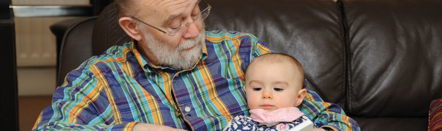 A grandparent and baby sitting on a chair